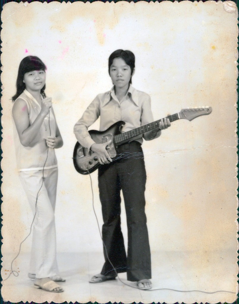 Two ladies having fun during a shooting session with an electric guitar and microphone. Photo: Lim Poh Kwuan
